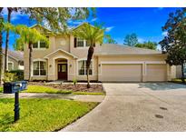 Two-story house with three-car garage and manicured lawn at 16159 Colchester Palms Dr, Tampa, FL 33647