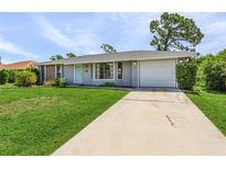 Single story home with gray exterior, attached garage, and well-manicured lawn at 455 Lenoir Nw St, Port Charlotte, FL 33948