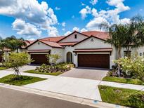 Two-story townhome with a Mediterranean style and two-car garage at 17231 Holly Well Ave, Wimauma, FL 33598