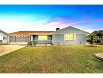 Charming single-story home with a brick exterior, well-manicured lawn, and attached garage at 609 Fox Hills Dr, Sun City Center, FL 33573