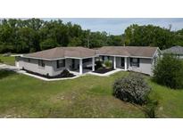 Charming single-story home featuring mature trees, a covered entry, and a well-maintained lawn at 10223 Us Highway 301, Dade City, FL 33525