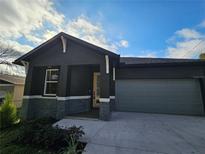 Modern home exterior with gray siding and attached garage at 3001 E 25Th Ave, Tampa, FL 33605