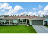 Single-story home with a light gray exterior and attached garage at 5457 Leeward Ln, New Port Richey, FL 34652