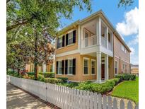 Charming two-story home with a white picket fence and lovely landscaping at 11329 Emerson Lake Dr, Riverview, FL 33578