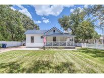Charming white cottage with a metal roof and porch at 5602 N Ola Ave, Tampa, FL 33604