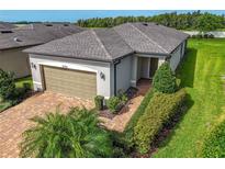 Single-story home with a two-car garage and landscaped yard at 18784 Coastal Shore Ter, Land O Lakes, FL 34638