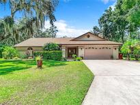 House with driveway, landscaping and mature trees at 3015 Forest Club Dr, Plant City, FL 33566