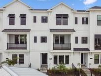 Modern townhouse with crisp white facade, black accents, and small balconies at 7404 Newham Ln, Sarasota, FL 34240