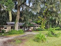 Ranch home with covered porch and lush landscaping on large lot at 15222 Lost Lake Ln, Lithia, FL 33547