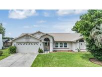 Exterior view of a single-story house with a two-car garage and a well-maintained lawn at 13199 Drysdale St, Spring Hill, FL 34609