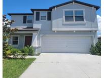 Two-story house with gray siding, dark brown accents, and a two car garage at 14443 Touch Gold Ln, Sun City Center, FL 33573