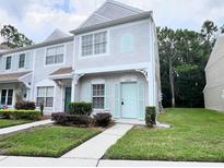 Two-story townhome with light-blue front door and well-maintained landscaping at 8628 Hunters Key Cir, Tampa, FL 33647