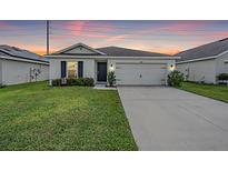 One-story house with a two-car garage and a neat lawn at 7864 Broad Pointe Dr, Zephyrhills, FL 33540