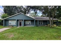 Charming single-story home with a well-maintained lawn and freshly painted exterior with neutral trim at 8013 N Ola Ave, Tampa, FL 33604
