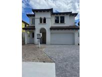 Elegant two-story home featuring a tile roof, arched entryway, and a spacious two-car garage at 320 W Park Ave, Tampa, FL 33602