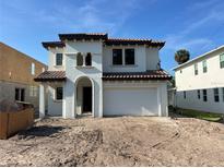 Mediterranean-style home featuring a stucco exterior, arched entryway, and a two-car garage at 320 W Park Ave, Tampa, FL 33602