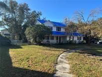 Two-story home with a blue tarp roof, front-facing porch, and walkway at 905 John Hunter Ct, Brandon, FL 33511