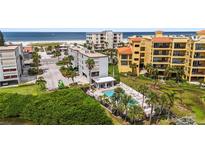 Aerial view of condo complex near beach, showcasing pool and water access at 10301 Gulf Blvd # 201, Treasure Island, FL 33706