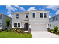Two-story home with neutral-colored stucco, a two-car garage, well-maintained landscaping and a paver walkway to the front door at 16013 7Th E Ave, Bradenton, FL 34212