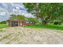 Brick ranch home with covered carport and large oak tree at 10912 672 Hwy, Riverview, FL 33579