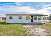 Charming single-story home with a freshly painted exterior and well-maintained lawn under a partly cloudy sky at 3396 Minnow Creek Dr, Hernando Beach, FL 34607