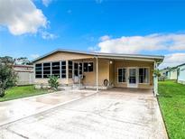 Charming single-story home featuring a cozy porch, lush green lawn, and long drive way perfect for outdoor Florida living at 35801 Verda Dr, Zephyrhills, FL 33541