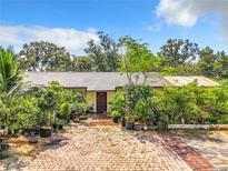 Ranch style home with brick driveway, lush landscaping, and a spacious front yard at 4300 41St N St, St Petersburg, FL 33714
