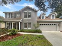 Two-story house featuring a gray exterior, large windows, and a double-car garage at 18122 Sugar Brooke Dr, Tampa, FL 33647