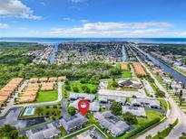 Stunning aerial view of the community with coastal access and lush greenery with water views in the background at 4844 Booth Bay Dr, New Port Richey, FL 34652