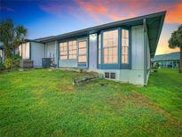 View of the home's exterior, showcasing a well-maintained lawn at 4844 Booth Bay Dr, New Port Richey, FL 34652