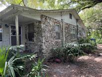 Cozy cottage with stone exterior and mature landscaping at 8707 127Th Ave, Tampa, FL 33637