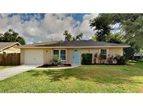 Single story home with a light beige exterior and teal door at 1154 Barbour Ave, Port Charlotte, FL 33948