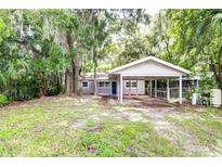 Cozy house exterior with carport nestled amongst lush trees at 645 George S St, Tarpon Springs, FL 34688