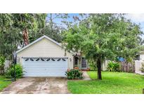 Charming yellow house with a two-car garage and well-maintained lawn at 5001 80Th Avenue E Cir, Sarasota, FL 34243