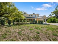 Charming yellow two-story home with black shutters and a welcoming front porch at 1109 Belcher Rd, Palm Harbor, FL 34683