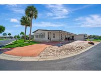 Single-wide mobile home with carport and paved driveway at 109 N Saint Thomas Cir, Apollo Beach, FL 33572