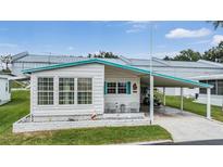 Quaint single wide mobile home with carport and landscaping at 37743 Mission Hills Ave, Zephyrhills, FL 33541