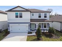 Charming two-story home features a covered entryway, attached two car garage and landscaped front yard at 4265 Big Sky Dr, Spring Hill, FL 34604