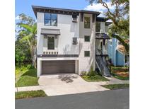 Contemporary two-story home features a two-car garage and well-manicured landscaping at 321 W Hanlon St, Tampa, FL 33604