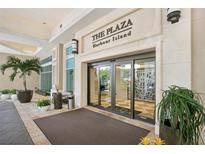 The Plaza Harbour Island building entrance with automatic doors and landscaping at 450 Knights Run Ave # 411, Tampa, FL 33602