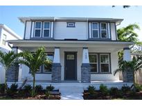 Charming two-story home featuring a welcoming front porch with decorative columns and lush landscaping at 759 48Th N Ave, St Petersburg, FL 33703