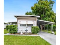 Charming single-story home with a carport, lush landscaping, and well-manicured lawn at 5116 Curran St, Zephyrhills, FL 33542