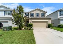 Charming two-story home features a manicured lawn, two-car garage, and beautiful curb appeal at 10744 Hawks Landing Dr, Land O Lakes, FL 34638