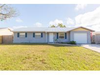 Ranch-style home with gray siding, metal roof, and spacious yard at 3935 Middlesex Pl, Sarasota, FL 34241