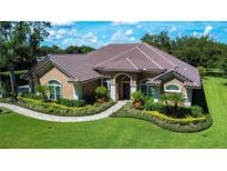 Single-Gathering home with tile roof, landscaping, and walkway at 10641 Echo Lake Dr, Odessa, FL 33556