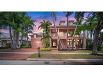 Two-story home with a pink facade, double garage and lush landscaping at 825 Islebay Dr, Apollo Beach, FL 33572
