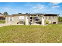 Cozy ranch home with a covered porch, well-maintained lawn, and landscaping at 5509 Moongate Rd, Spring Hill, FL 34606