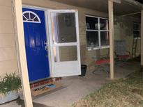 Inviting front porch with blue door and welcoming mat at 6115 7Th Ave, New Port Richey, FL 34653