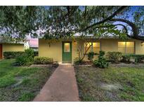 Yellow condo building with green door entrance at 401 Dorchester Pl # 58, Sun City Center, FL 33573
