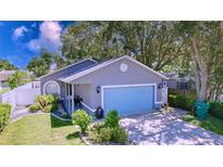 Charming single-story home features a blue garage door, manicured lawn, and cozy porch at 4477 67Th N St, St Petersburg, FL 33709